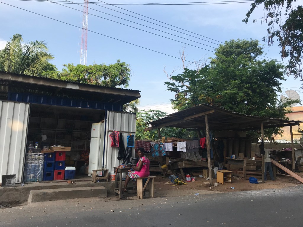 A seamstress sews outside her container shop in Accra Ghana