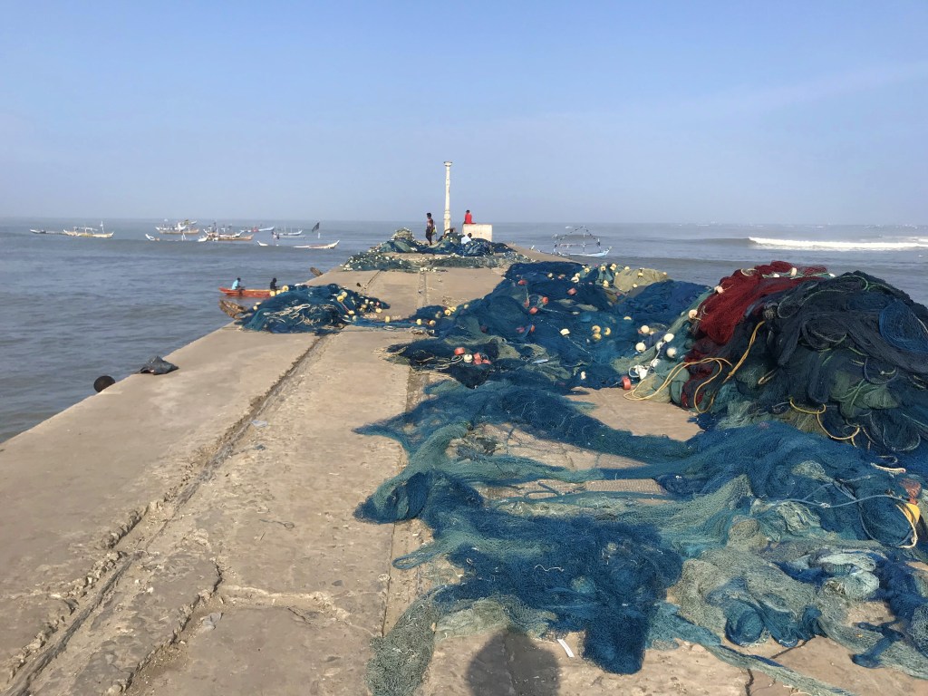 Fishing nets on the pier at Jamestown Accra. Fishing boats are in the background