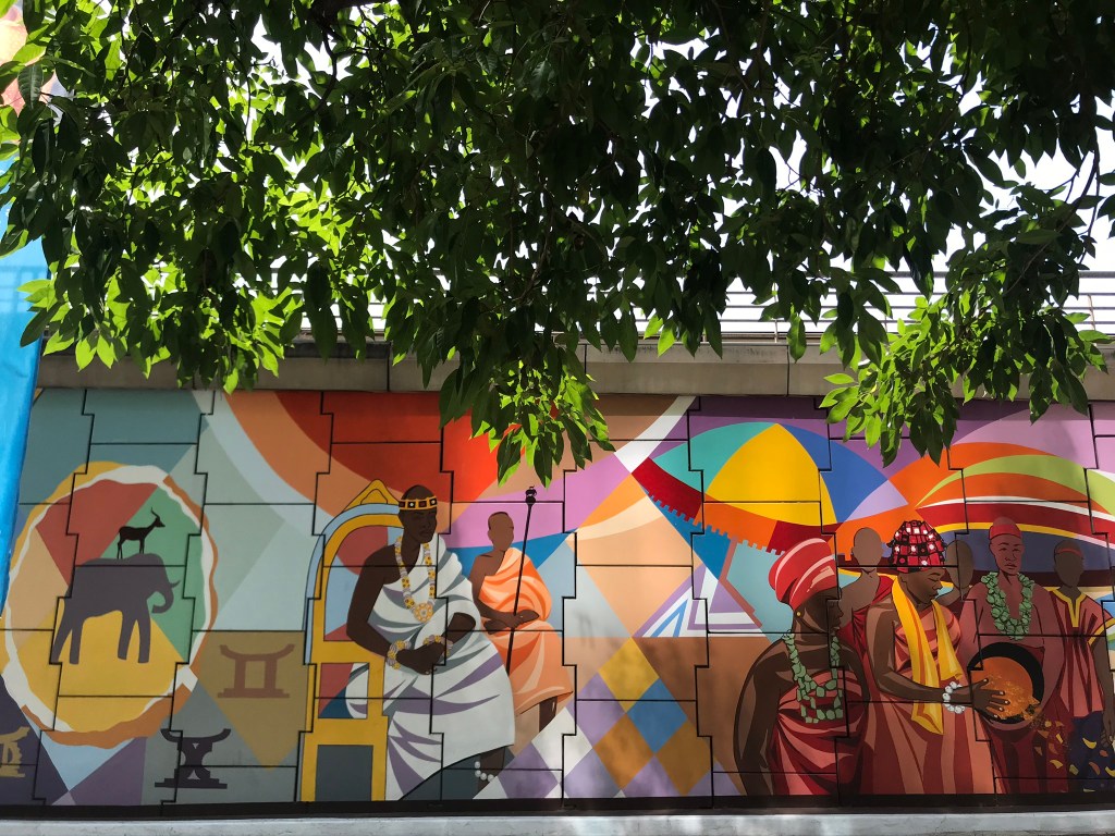 Accra Street Art - Murals at the Ako Adjei interchange depicting a Ghanaian chief, stools and women with beads around their necks. 