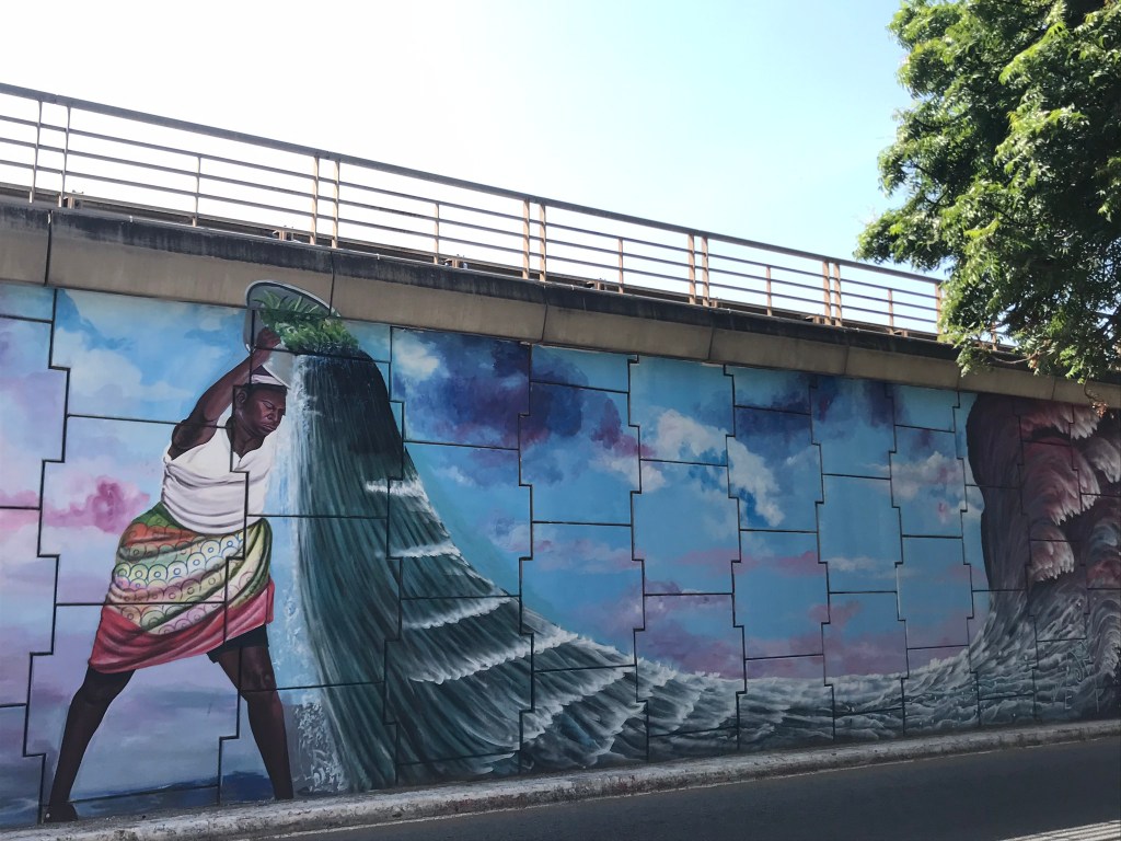Ghana Street art - Murals at the Ako Adjei interchange Accra Ghana. A woman is holding a huge wave. 