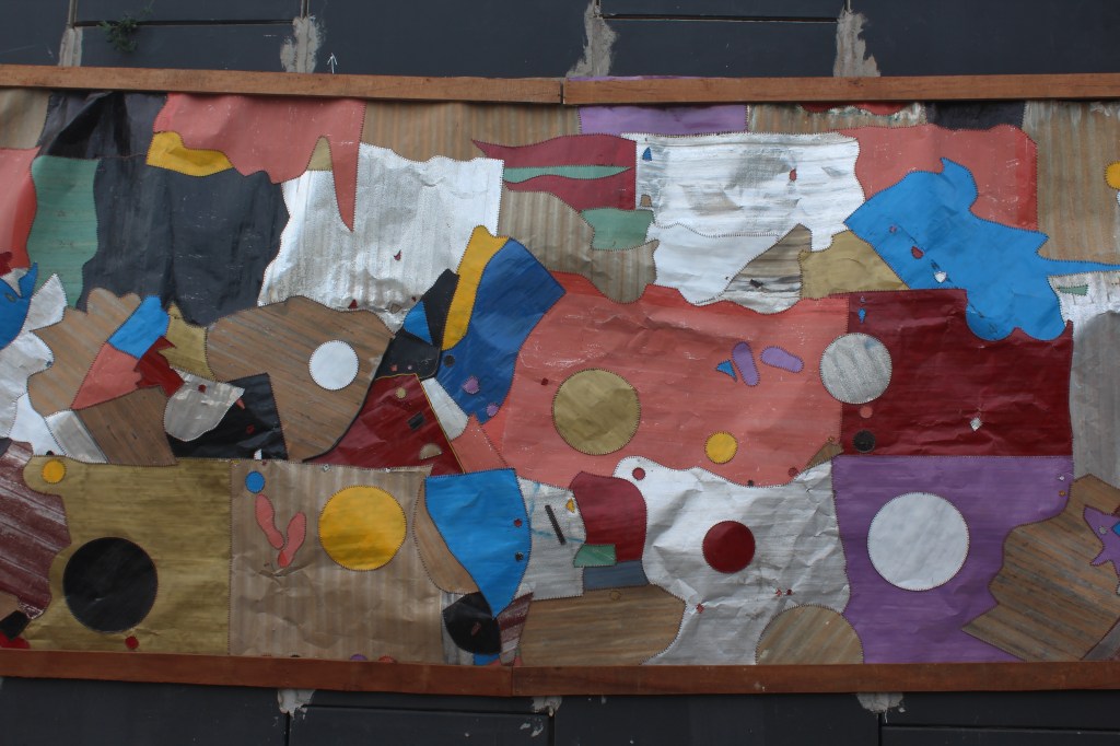 Ghana street art - A Metal artwork by Ghanaian artist Tei Huagie 'National Inspiration' Mural on the side of the road of Ako Adjei interchange in Accra Ghana
