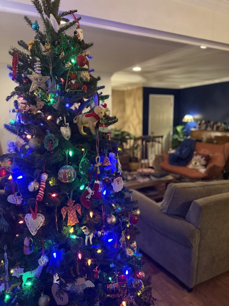 A fraser fir Christmas tree full of decorations in a lounge